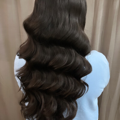 Beauty by Krimse offers semi-bridal hairstyling services with soft curls and an elegant finish for special occasions. Semi-bridal hairstyle with soft curls and a polished finish.