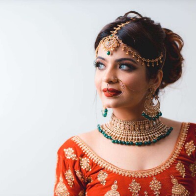 Beauty by Krimse perfects bridal makeup with intricate Bride holding a bouquet with intricate makeup details.