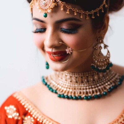 Elevate your bridal look with bold lip colors and chic hairstyles Bride with bold red lips and a high bun hairstyle.