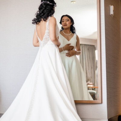 Beauty by Krimse creates romantic bridal looks with soft waves, Bride holding a bouquet with her hair styled in soft waves.